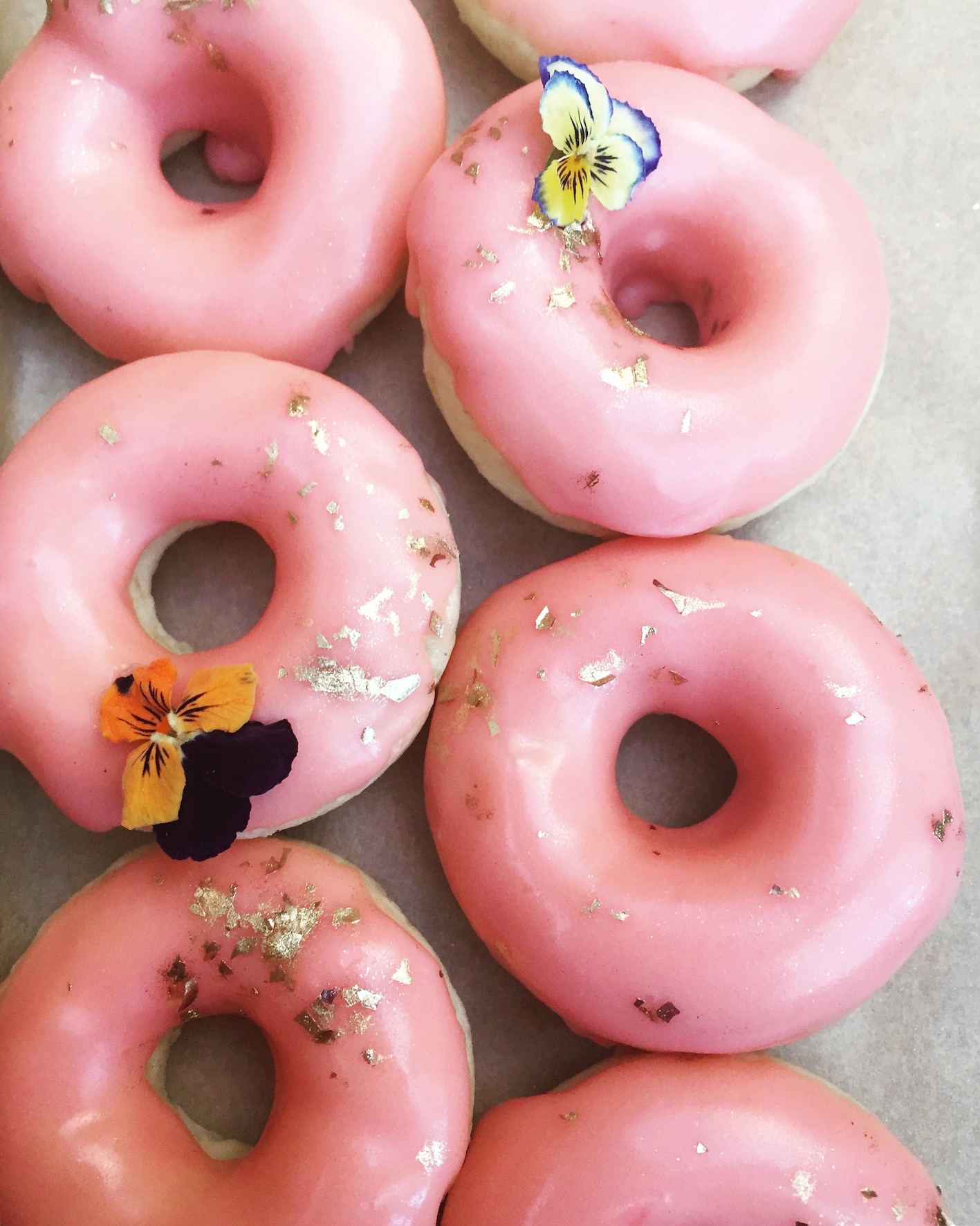 image de donuts coloridos cor de rosa com flores por cima